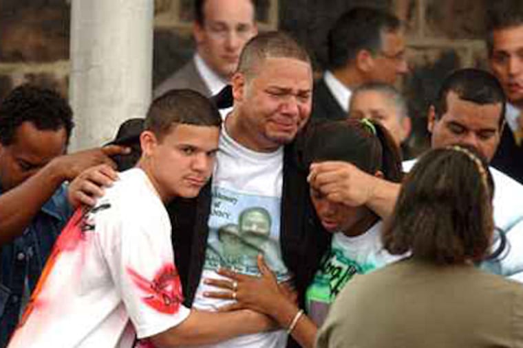David Agosto, father of victim Daniel Agosto, is comforted while leaving Tabernacle of Faith Church in Camden. (Sarah J. Glover / Staff / File)