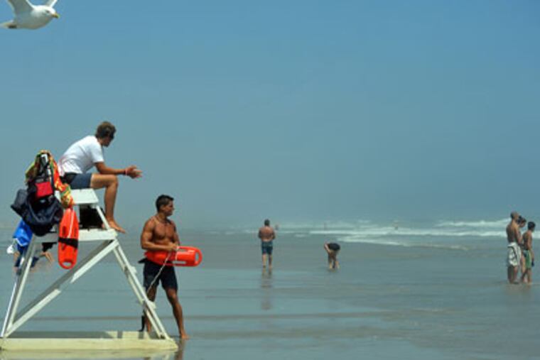 Avalon Beach Patrol members Bryan Chismar (left) and Jamie DeFelice watch closely. As Hurricane Bill nears, officials warned people to stay out of the water if there are no lifeguards. (Sharon Gekoski-Kimmel / Staff Photographer)