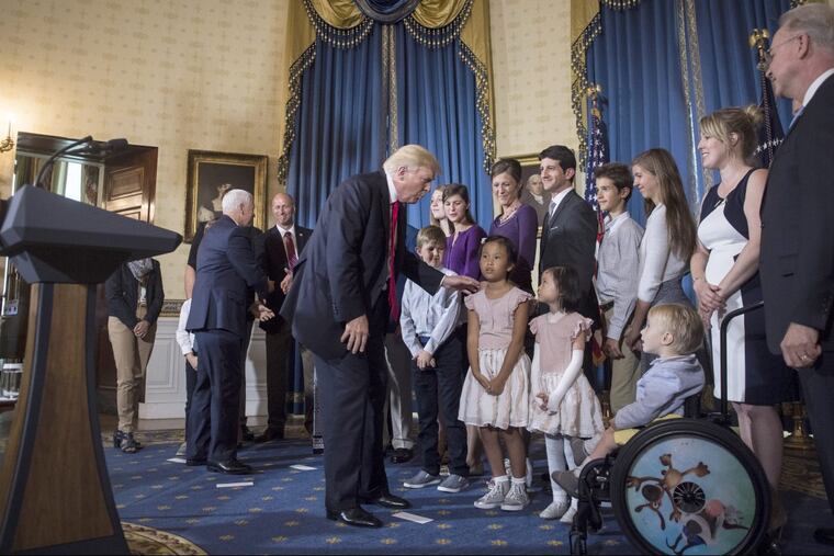 President Donald Trump greets "victims of Obamacare" after speaking at a White House event in late July. Trump’s tax bill ended the Obamacare penalty for not having insurance but it won’t take effect until 2019.
