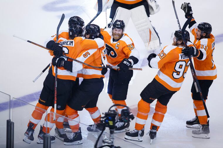 Flyers defenseman Phil Myers (5) is embraced by teammates as he celebrates his game-winning goal in overtime.