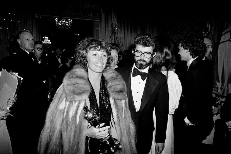 Marcia Lucas, left, film editor and wife of director George Lucas, right, carries her Oscar statuette as they arrive at a post-Academy Awards party at the Beverly Hilton Hotel in Los Angeles, April 4, 1978.