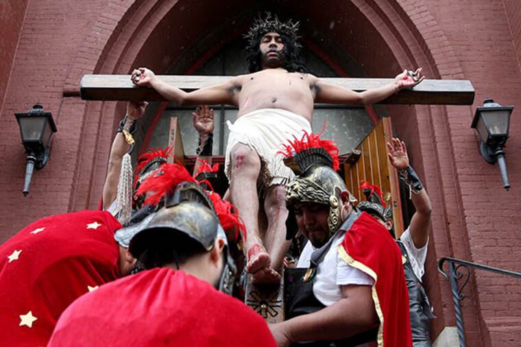 Jose Miguel Almaraz, in the role of Jesus, is lifted up on a wooden cross during the reenactment of the Stations of the Cross put on by Annunciation of the Blessed Virgin Mary Roman Catholic Church Friday, April 3, 2015.