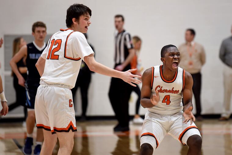 Cherokee's Olare Olapido (right) celebrates a second half three-pointer against Shawnee in the opening round of the South Jersey Group 4 tournament on Monday. Cherokee's Zach Miller is on the left.