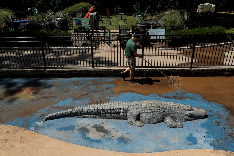 Jamie Sheard, a guest services manager, cleans up the playground at the Elmwood Park Zoo in Norristown, Pa. on Wednesday, August 5, 2020. Isaias moved through the Philadelphia area Tuesday, bringing heavy rain and strong winds that caused destruction across the region, flooding roadways and knocking down trees and power lines. Clean-up and damage assessment is occurring around the area.