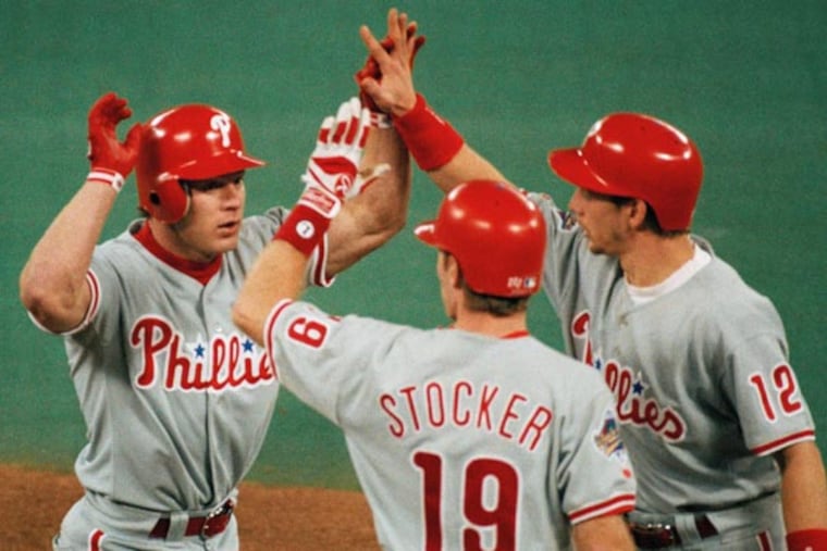 Lenny Dykstra, left, is greeted at the plate by Kevin Stocker, center, and Mickey Morandini after Dykstra's three-run home in the seventh inning against the Toronto Blue Jays in Game 6 of the World Series on, Oct. 23, 1993, at SkyDome in Toronto. (Elise Amendola/AP file)