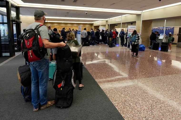 Passengers queue up at the ticketing counter for Southwest Airlines flights in Eppley Airfield Omaha, Neb., on Sunday.