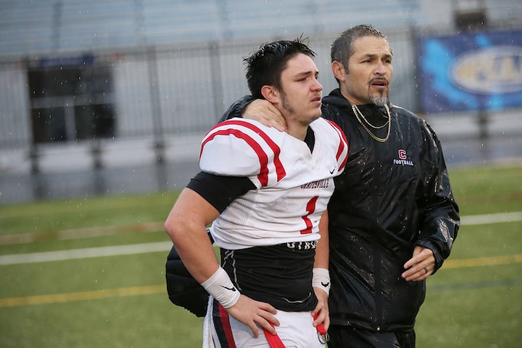 Coatesville football coach Matt Ortega (right) with his son, Ricky, who throws both footballs and javelins.
.