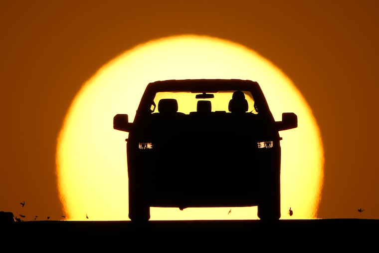 A motorist is silhouetted by the setting sun March 26 in Lenexa, Kan.