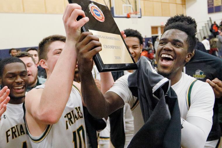 Bonner-Prendergast's Donovan Rodriguez raises the championship plaque with teammate Connor Eagan (No. 10) after the Friars' 64-58 win over Imhotep Charter in the District 12, Class 4A city title game.