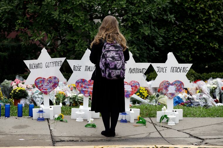 A person stands in front of Stars of David that are displayed in front of the Tree of Life Synagogue with the names of those killed in Saturday's deadly shooting in Pittsburgh, Monday, Oct. 29, 2018.