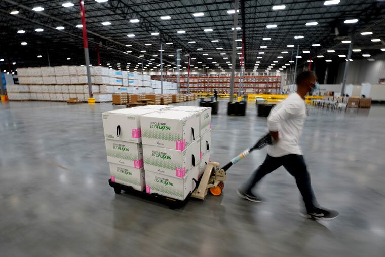 Boxes containing the Moderna COVID-19 vaccine are moved to the loading dock for shipping at the McKesson distribution center in Olive Branch, Miss., on Sunday.