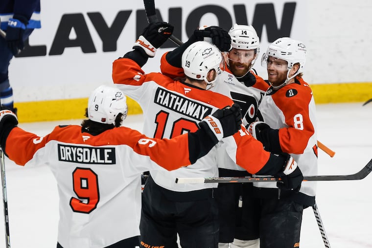 Flyers' captain Sean Couturier (center) celebrates with teammates after his goal against the Winnipeg Jets on Saturday.
