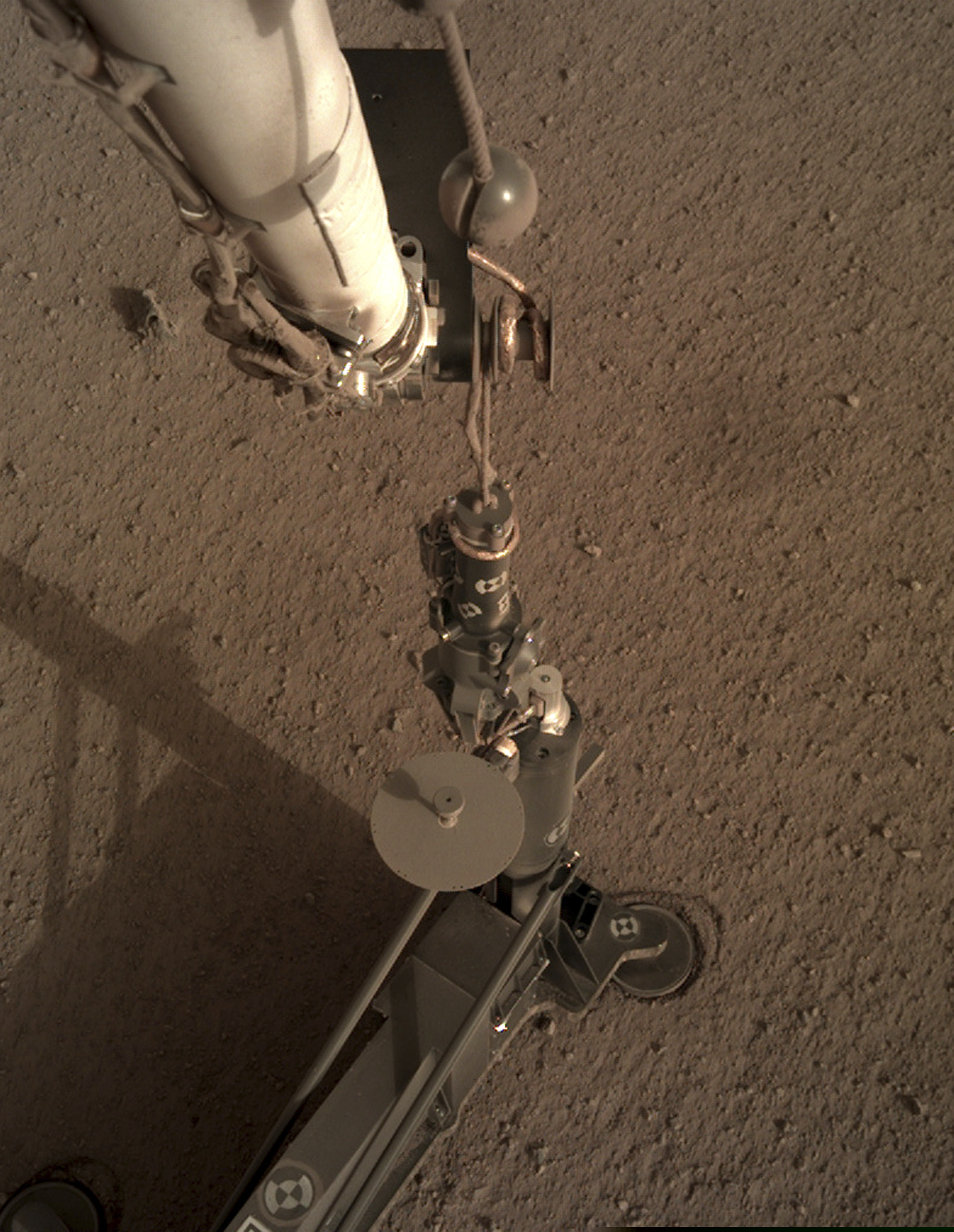 This photo provided by NASA/JPL-Caltech shows an image acquired by NASA's InSight Mars lander using its robotic arm-mounted, Instrument Deployment Camera (IDC). The image was acquired on March 1, 2019, Sol 92 where the local mean solar time for the image exposures was 16:53:31.055 PM. Scientists say NASA's newest Mars lander has started digging into the red planet, but has hit a few snags. (NASA / JPL-Caltech via AP)