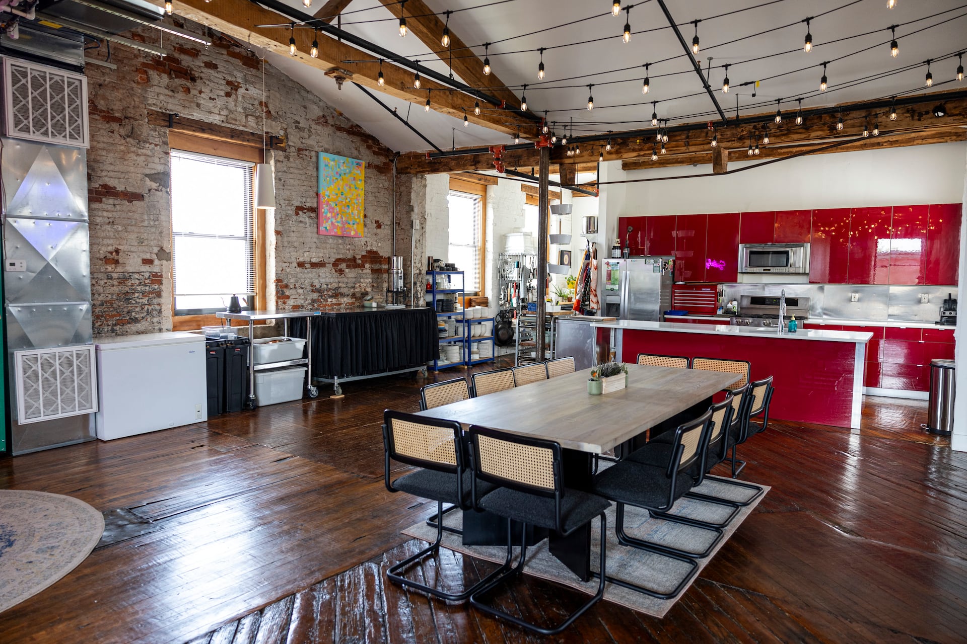 Chef Jen Carroll's 3,000-square-foot Kensington loft features high ceilings, exposed beams, hardwood floors, and cheery red kitchen cabinets.