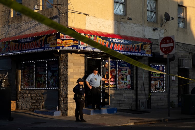 Police stand at the scene of a shooting at 20th and Federal Streets in the Point Breeze section of Philadelphia on Monday.
