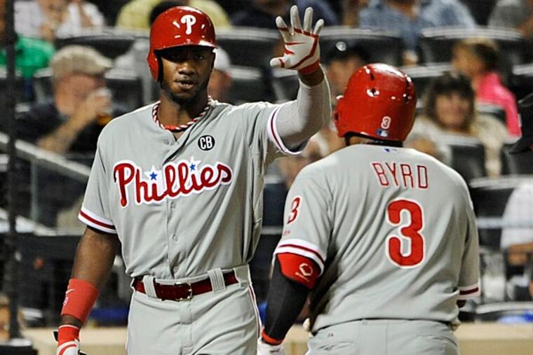 New York Mets catcher Travis d'Arnaud watches as Philadelphia Phillies
Domonic Brown, center, greets Marlon Byrd, right, at home plate after
Byrd hit a solo home run off of New York Mets starting pitcher Bartolo
Colon in the fifth inning of a baseball game at Citi Field on Saturday, Aug. 30, 2014, in New York. (AP Photo/Kathy Kmonicek)