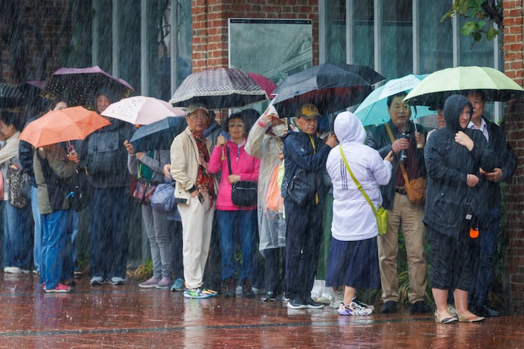 Heavy rain falls over visitors at Independence Mall on Wednesday, and shower chances are as persistent as the rain deficit.
