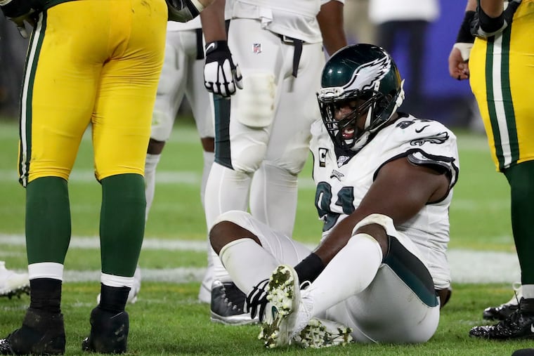 Eagles defensive tackle Fletcher Cox grabbed his right leg after he was injured against the Packers.