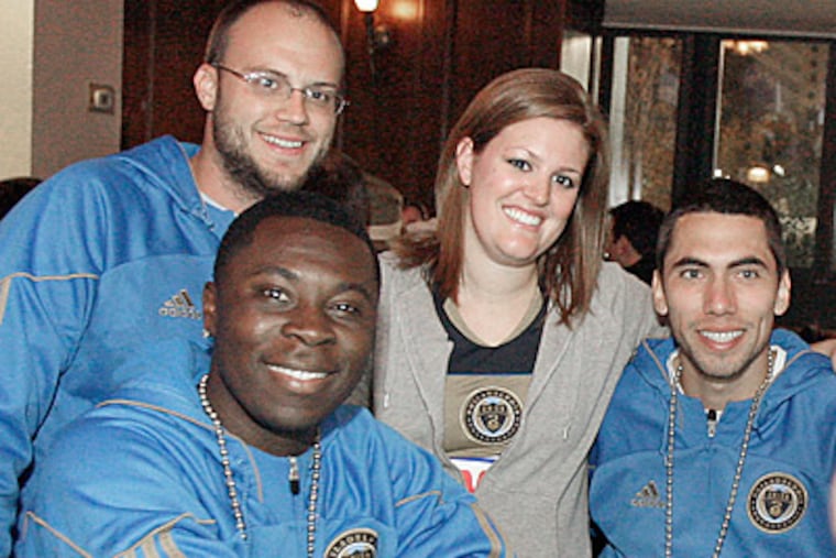Matt Vlock and Michelle Stella (standing) pose with Union players Freddy Adu and Gabe Farfan. (Elizabeth Robertson/Staff Photographer)