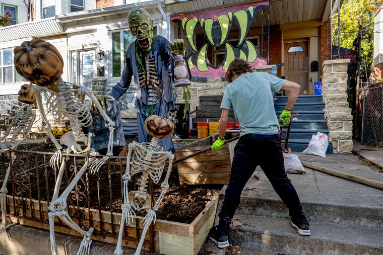 Sam Nicotera, 15, works with other West Philly neighbors to decorate their homes near 51st and Catharine Street last. He may need a sweater Tuesday night.