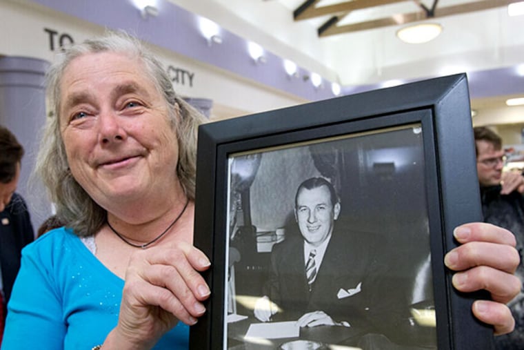 Mary Parsons, of Northfield, with a family photo of her great-uncle Frank "Hap" Farley, during the re-dedication of a refurbished painting housed in the Atlantic City Expressway rest stop named for him. ( DAVID M WARREN / Staff Photographer )