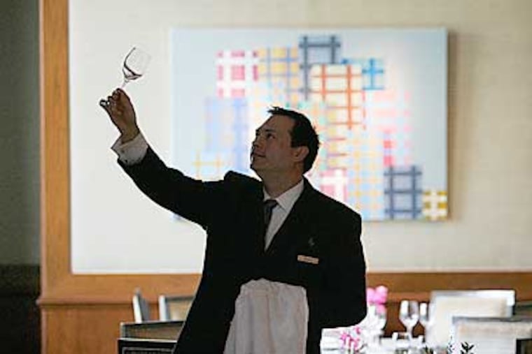 Stephen Flis, a waiter at the Fountain Restaurant, polishes the glassware prior to the restaurant opening for the evening. The Four Seasons boasts one of the best restaurants in the city. ( Michael Bryant / Staff Photographer