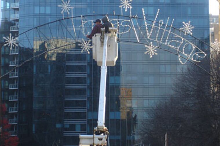 Crews remove the word "Christmas" from the sign at Dilworth Plaza. (VANCE LEHMKUHL / Staff)
