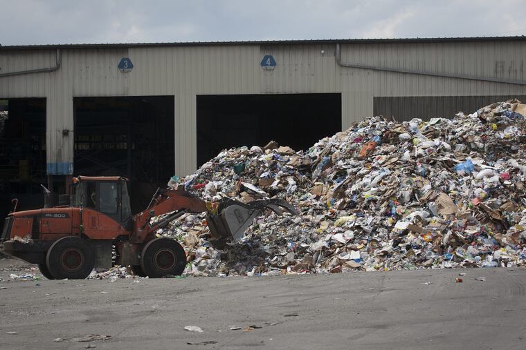 A loader moves waste and recyclables at Republic Services' recycling processing plant in the Gray's Ferry neighborhood of Philadelphia, Pa., on the afternoon of Tuesday, July 17, 2018.