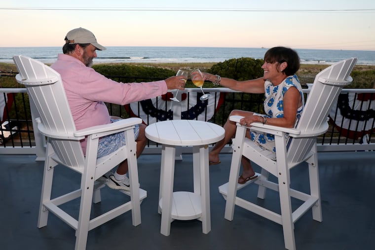 Katie and Randy Zakreski enjoy a glass of wine on their front porch, which faces the ocean at their home in Strathmere.