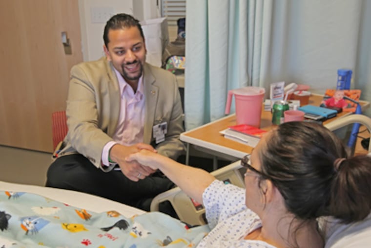 Nasir shares a moment with Shereen Semple, who was recovering from surgery. "I just let the patient know I'm here for them," he says. (Michael Bryant / Staff Photographer)