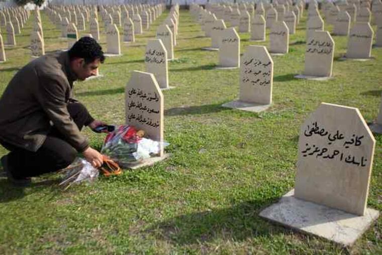 In Halabja in northern Iraq, a man places flowers on the grave of a victim of the 1988 chemical attack for which Ali Hassan al-Majid - "Chemical Ali" - was convicted yesterday. The attack came to symbolize the brutality of Saddam Hussein's rule.