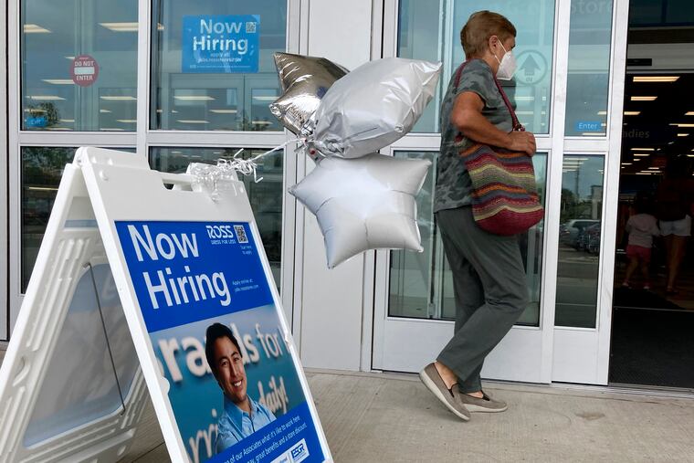 A shopper passes a hiring sign while entering a retail store in Morton Grove, Ill., Wednesday, July 21, 2021. Despite an uptick in COVID-19 cases and a shortage of available workers, the U.S. economy likely enjoyed a burst of job growth last month as it bounces back with surprising vigor from last year’s coronavirus shutdown.