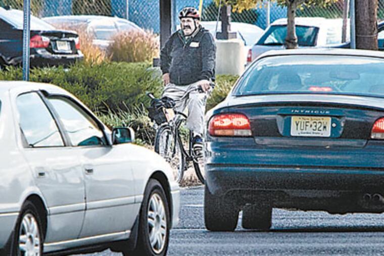 Chris Cominetto of Cherry Hill waits for the traffic light to change during his ride to work. ( David M Warren / Staff Photographer)