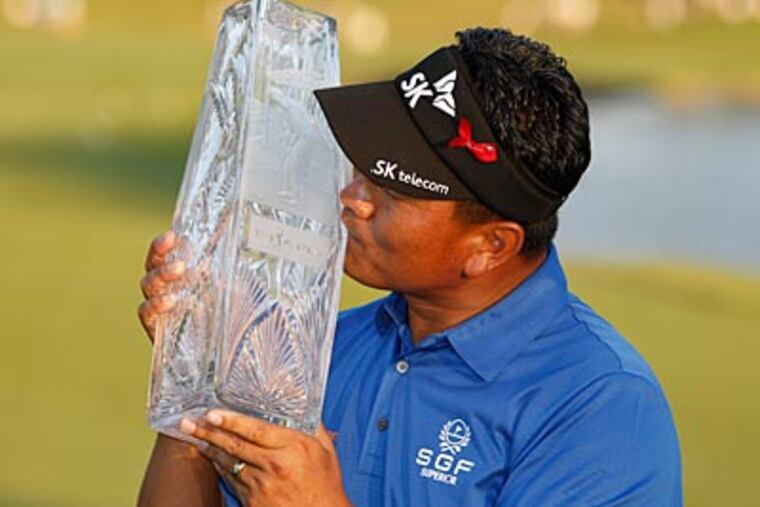 K.J. Choi kisses his trophy after winning The Players Championship, finishing 13-under par. (Lynne SladkyAP Photo)