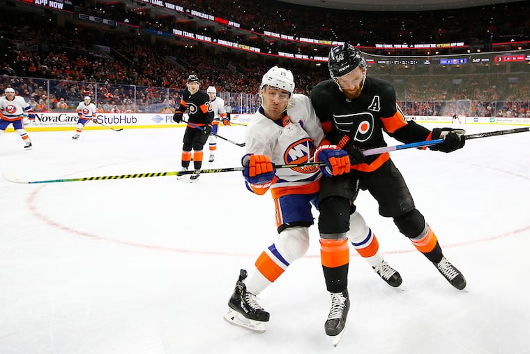 Flyers center Sean Couturier (right) checks New York Islanders right winger Cal Clutterbuck during an early-season game. Couturier could win his first Selke Trophy as the NHL's best defensive forward.