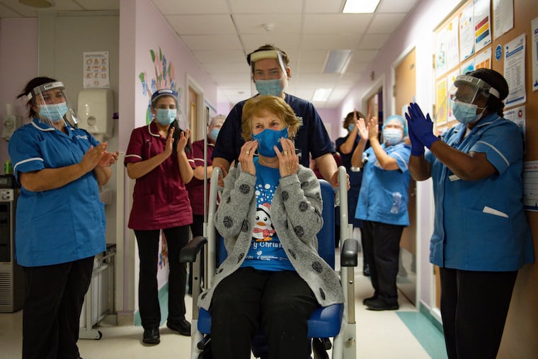 Margaret Keenan, 90, is applauded by staff as she returns to her ward after becoming the first patient in the U.K. to receive the Pfizer-BioNTech COVID-19 vaccine, at University Hospital, Coventry, England, on Tuesday.