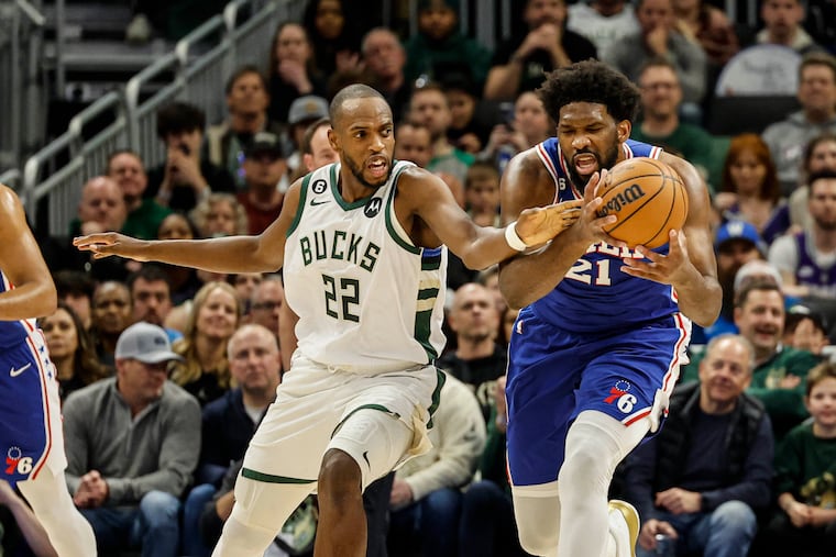 The Sixers' Joel Embiid and the Bucks' Khris Middleton try to gain control of the ball. Embiid finished with 28 points while Middleton had 19.