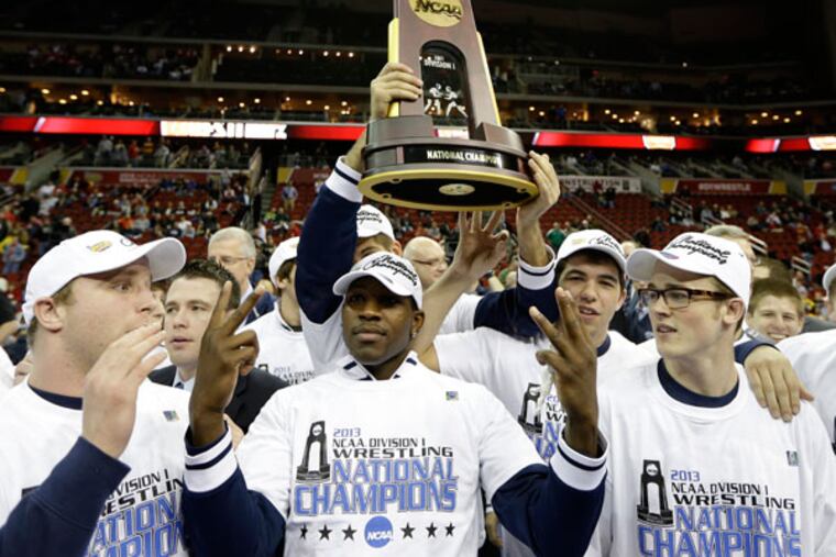 Penn State wrestlers celebrate with the trophy after winning the team championship at the NCAA Division I wrestling championships, Saturday, March 23, 2013, in Des Moines, Iowa. (Charlie Neibergall/AP)