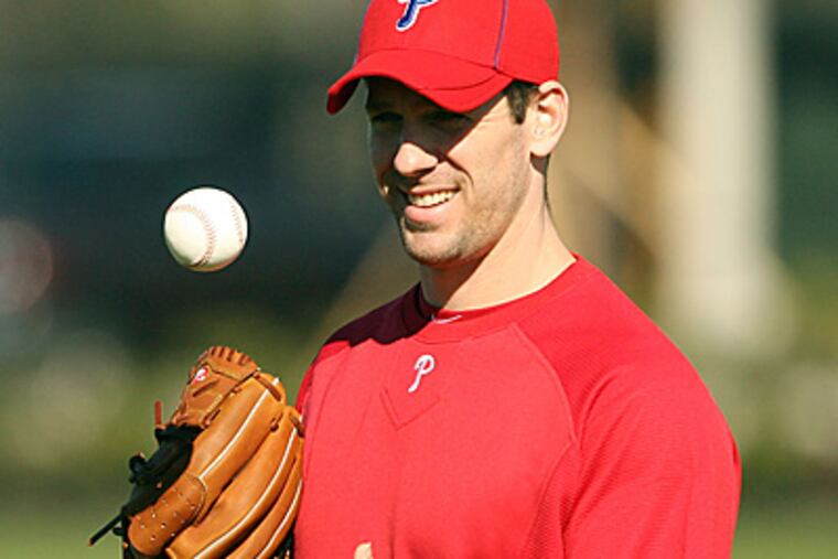 Cliff Lee tosses the ball around while warming up at Bright House Field in Clearwater. (Yong Kim/Staff Photographer)