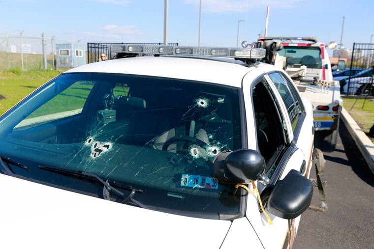 With bullet holes in the front windshield, a State Police cruiser is towed into Barracks K on Belmont Avenue on Tuesday, Nov. 24, 2015.