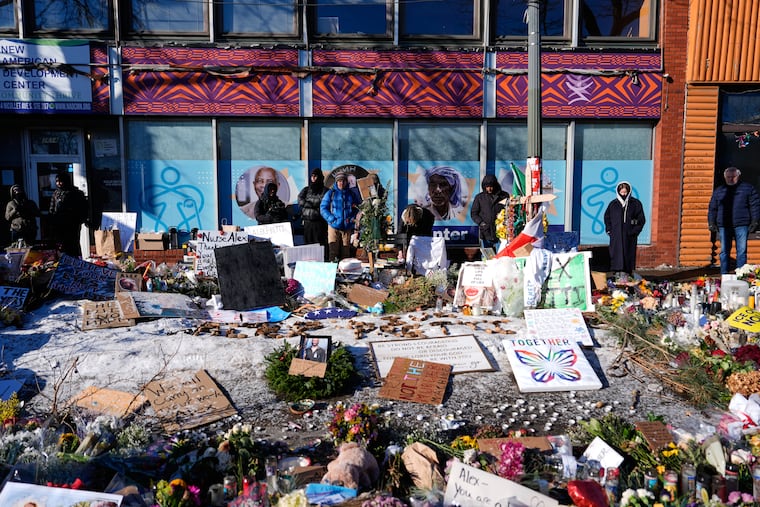 People visit a memorial for Alex Pretti at the scene where the 37-year-old was fatally shot by a U.S. Border Patrol officer over the weekend, Tuesday, Jan. 27, 2026, in Minneapolis.