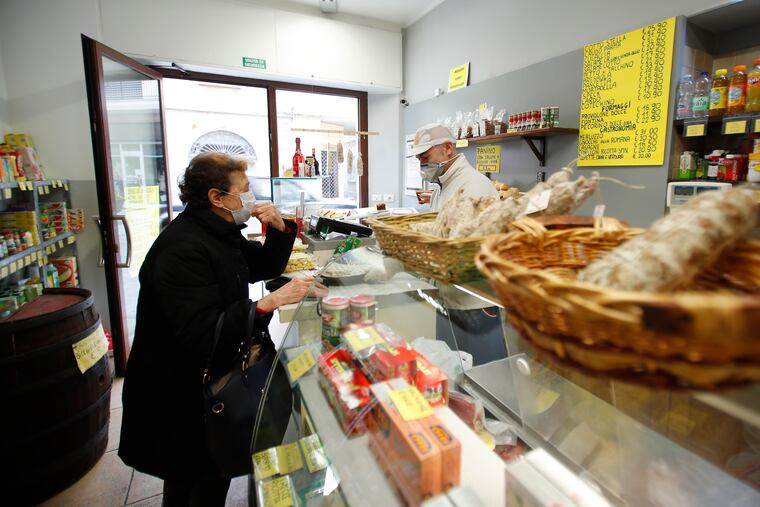 An elderly woman buys food in a deli meat and cold cuts shop in Codogno, Italy, in March.