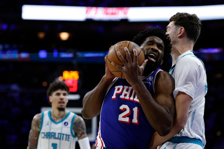 Sixers center Joel Embiid gets fouled driving to the basket against Charlotte Hornets center Ryan Kalkbrenner in the first quarter of Saturday's game.