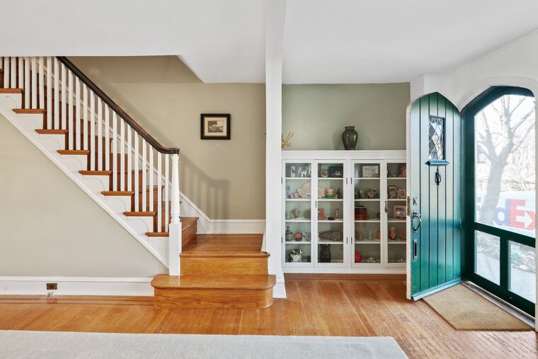 The living room has original hardwood floors, custom built-ins, coat closet, and cottage-style Tudor windows.