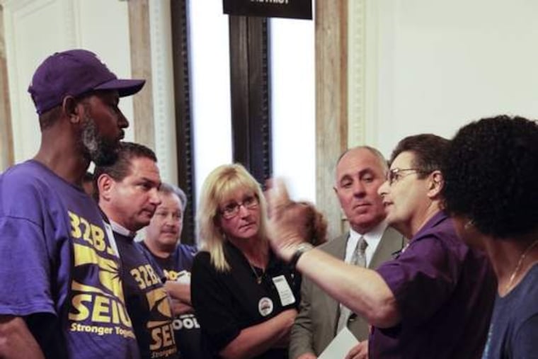 George Ricchezza, who heads the school employees' Local 1201, talks with school district employees during on recess from a City Council hearing Thursday at City Hall.
ELISE WRABETZ / Staff Photographer