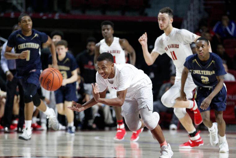 Jhamir Brickus (center) of Coatesville passes the ball ahead to teammate Dapree Bryant in 2017.
