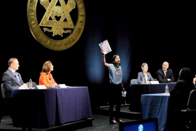 From left, State treasurer Rob McCord, former state environmental protection secretary Katie McGinty, U.S. Rep. Allyson Schwartz and businessman Tom Wolf look on as an unidentified woman, center, interrupts the Pennsylvania Democratic Gubernatorial Primary Debate on Monday, May 12, 2014, in Philadelphia.