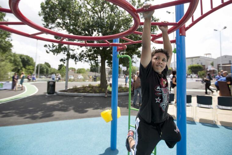 Elvis Berrocal, 12, plays on the monkey bars after the ribbon cutting ceremony at Jose Manuel Callazo Playground June 19, 2017. The Trust for Public Land supported the city and Philadelphia School District in an effort to create public green spaces in areas where they were more than a 10-minute walk away, an effort that was started under Mayor Nutter.