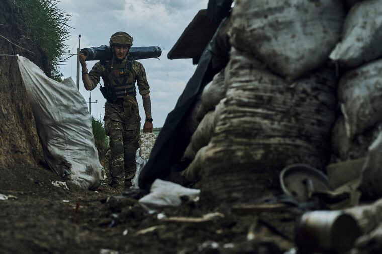 A Ukrainian soldier carries supplies in a trench at the frontline near Bakhmut in the Donetsk region, Ukraine, Monday, May 22.