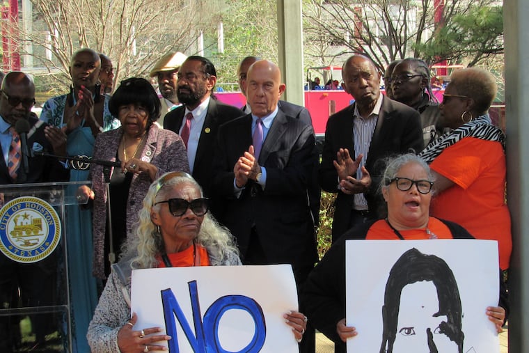 People hold up signs at a news conference on March 3 in Houston while protesting the proposed takeover of the city's school district by the Texas Education Agency. Texas officials on Wednesday announced a state takeover of Houston's nearly 200,000-student public school district, the eighth-largest in the country, acting on years of threats and angering Democrats who assailed the move as political.
